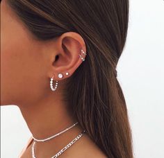 a close up of a person wearing some kind of necklace and earring with pearls on it