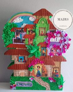 a paper cut out of a house with trees and flowers on the front, next to a sign that says madys creations