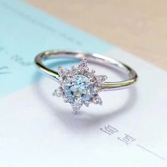 a ring with an oval blue topaz surrounded by small white diamonds