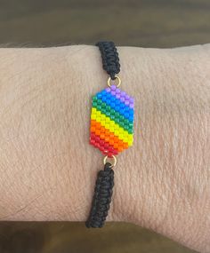 a person wearing a bracelet made out of legos on their arm with a black string