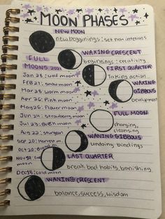 a spiral notebook with moon phases written in purple and black ink on it, sitting on a table