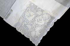 New old stock, never used vintage hanky with fancy and ornate hand embroidery. One corner is heavily embellished with a rose motif, all done in white. This is the perfect bridal accessory for the bride to carry on her wedding day. Hand rolled edges are framed perfectly by embroidered scalloped corners. Made of white linen and measuring 13 inches. Original Lady Heritage tag in tact. Hand made in Madeira, Portugal. Elegant White Floral Embroidered Handkerchiefs, Elegant White Handkerchiefs With Floral Embroidery, Elegant White Handkerchiefs With Machine Embroidery, Vintage Embroidered Handkerchiefs For Wedding, Vintage Embroidered Wedding Handkerchiefs, Vintage Floral Embroidery Wedding Handkerchiefs, Embroidered Cream Handkerchiefs For Wedding, Wedding Embroidered Cream Handkerchiefs, Vintage Wedding Handkerchiefs With Machine Embroidery