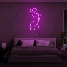 a bed in a room with a neon sign on the wall above it and a window