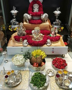 a table topped with lots of different types of food and silver dishes filled with fruit