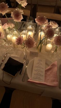 the table is set with flowers and candles