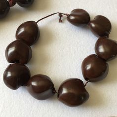 "Genuine Kukui Nut lei Nuts Hawaiian necklace, Bracelet & Earrings Set. Necklace Black ribbon holds polished brown nuts. Great natural gift for graduation, wedding, or birthday. There's 16 polished kukui nuts. The ribbon is knotted in between each nut. Length is about 33\" Bracelet is 10\", 9 kukui nuts on a cord. Can be shortened/adjusted to about 6\" to 10\" wrist size. Earrings are single kukui nuts, clip on style earrings with gold accents. They are perfect for any hula costumes, wedding Brown Large Beads Jewelry Gift, Coachella Necklace, Kukui Nut Lei, Hawaiian Necklace, Gift For Graduation, Peace Necklace, Peace Sign Necklace, Desert Hot Springs, Kukui Nut