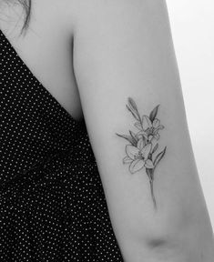 a black and white photo of a woman's arm with a flower tattoo on it