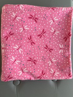 the pink and white dragonflys are on this pillow cover, with polka dots