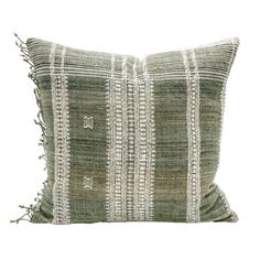 a green and white striped pillow with fringes on the front, sitting against a white background