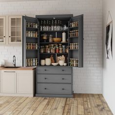 an open cabinet in the middle of a kitchen with wooden floors and white brick walls