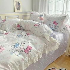 a bed with hello kitty comforter and pillows on it in a bedroom next to a pair of slippers