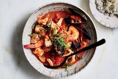 a white bowl filled with food next to rice