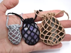 three small crocheted bags are held in someone's hand