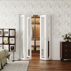 an open door leading into a bedroom with white walls and wood flooring on the side