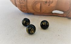 Lot of beads with the inscription "OM Mani Padme Hum". They are black with gold-colored inscriptions. They will be used to create your jewelry. Size: 1cm Hole size: 1mm Shipping will be careful and fast. Do not hesitate to visit the Nepalmashop store for more choice in ethnic beads and findings! See you soon...Namaste! Black Beads For Festivals Gift, Traditional Black Beads For Gift, Spiritual Black Beads For Jewelry Making, Traditional Black Beads For Meditation, Handmade Traditional Black Beads, Traditional Handmade Black Beads, Traditional Black Beads With Large Beads, Traditional Large Black Beads, Traditional Black Large Beads