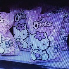 three hello kitty bags sitting on top of a shelf in front of a tv screen