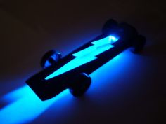 a skateboard is lit up in the dark with blue light coming from its wheels