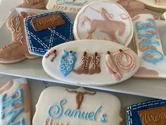 decorated cookies are arranged on top of each other in the shape of cowboy boots and horseshoes