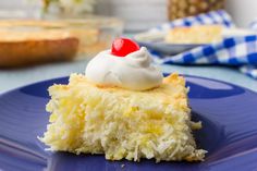 a piece of cake with whipped cream and a cherry on top sits on a blue plate