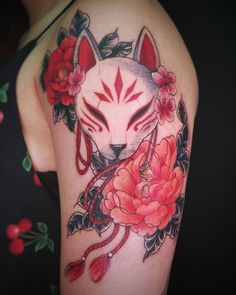 a woman's arm with a tattoo on it that has flowers and an animal