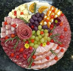 a platter filled with meats, cheese and fruit