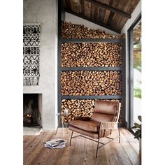 a living room with wood stacked on the wall and a chair in front of it