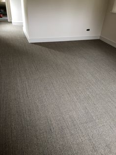 an empty room with carpeting in the middle and no one on the floor inside