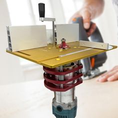 a person using a sanding machine on top of a piece of wood and metal