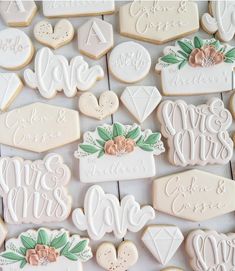 decorated cookies are arranged in rows on a white table top with the words love and mrs written across them