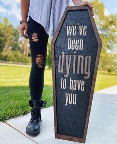 a woman standing next to a sign that says we've been dying to have you