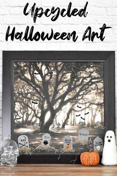 a framed halloween art project with pumpkins, ghost heads and trees in the background