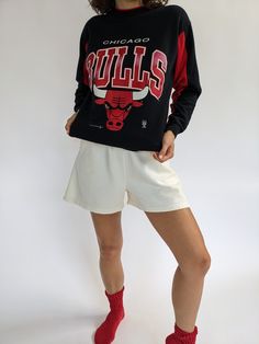 Our absolute favorite Chicago Bulls sweatshirt! Features the classic Chicago Bulls red coloring in the ribbed neckline and inner sleeves. The middle front of the sweatshirt showcases a beautiful print with the Chicago Bulls Logo. The perfect piece to pair with the AGOLDE 90's Pinch Waist Jean. 50% polyester 50% cotton Tag reads Official Licensed Product NBA - Made in USA Recommended for size xs-s, depending on the desired fit. Modeled on a small frame. Please refer to the measurements listed bel Streetwear Sweatshirt With Raglan Sleeves And Ribbed Cuffs, Raglan Sleeve Sweatshirt With Ribbed Cuffs For Streetwear, Relaxed Fit Throwback Tops For Fall, Red Varsity Top With Ribbed Cuffs, Throwback Style Cotton Tops For Fall, Throwback Cotton Tops For Fall, Relaxed Fit Raglan Sleeve Sweatshirt With Graphic Print, Long Sleeve Sweats With Graphic Print In Sportswear Style, Red Sporty Sweatshirt With Relaxed Fit