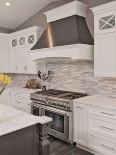 a stove top oven sitting inside of a kitchen next to white cabinets and counter tops