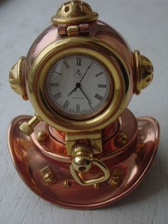 a clock sitting on top of a saucer with gold trimmings and handles