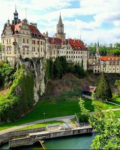 an old castle on top of a hill next to a river