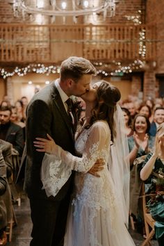 a bride and groom kissing in front of an audience