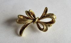 Hi there and welcome to 'In the magpie's nest' For sale - A vintage 80's bow shaped brooch pin gold tone Brooch shape - Bow  Measurement - 2.6x1.8cm's  Metal - Gold tone Era - 1980's -------------------------------------------------------------------------------------------------- Condition - Good vintage condition (see pics) Your brooch will come packaged in a gift box -------------------------------------------------------------------------------------------------- Important info - All the ite Gold Brooches With Decorative Bow For Gift, Gold Brooch With Decorative Bow As Gift, Gold Bow Brooches For Formal Occasions, Formal Gold Brooch With Bow, Vintage Gold Brooch With Bow, Vintage Gold Jewelry With Decorative Bow, Gold Vintage Brooch With Bow, Vintage Wedding Brooch With Bow Detail, Vintage Wedding Brooch With Bow