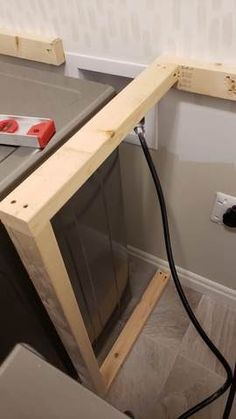 an electrical outlet in the corner of a room that is being built with plywood