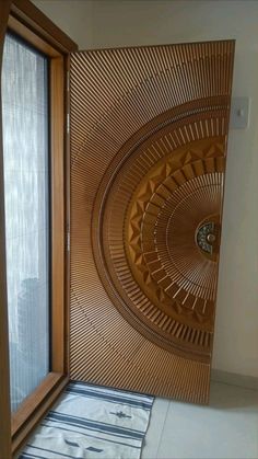 a wooden door with an intricate design on the outside and inside, in front of a window