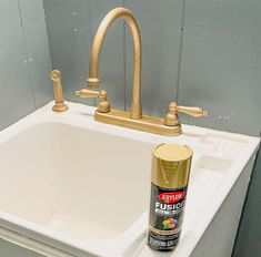 a white sink sitting next to a golden faucet