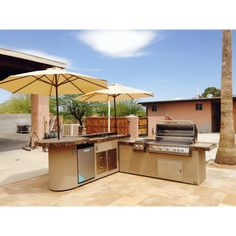 an outdoor kitchen with umbrellas and grill