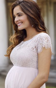 a pregnant woman in a white dress smiling