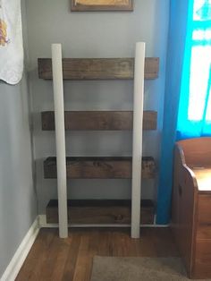 a room with wooden shelves and blue curtains on the window sill, next to a dresser