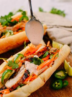 a spoon is being used to scoop into a sandwich with meat and veggies