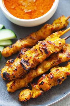 grilled chicken skewers on a plate with dipping sauce