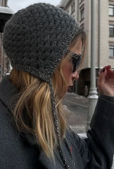 a woman wearing a gray hat and sunglasses