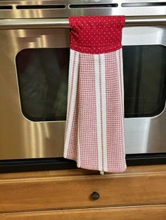 a kitchen towel hanging from the handle of an oven door in front of a stainless steel stove