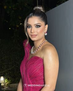 a woman in a pink dress posing for the camera