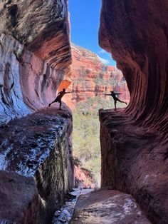 two people standing on the edge of a canyon