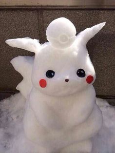 a white stuffed animal sitting on top of snow